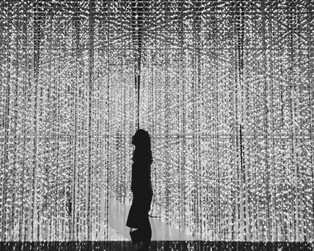 Silhouette of woman standing against bright lights